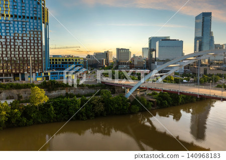 Nashville, big city in Tennessee at sunset. Downtown skyscrapers rise above riverfront with bridge and warm sundown glow over metropolitan skyline Nashville, big city in Tennessee at sunset. Downtown skyscrapers rise above riverfront with bridge and warm sundown glow over metropolitan skyline 140968183