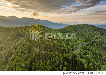 Road trip travel in Appalachian mountains at sunset. Car driving on parkway through woods nature in summer season. Colorful forest in Tennessee Road trip travel in Appalachian mountains at sunset. Car driving on parkway through woods nature in summer season. Colorful forest in Tennessee 140968231