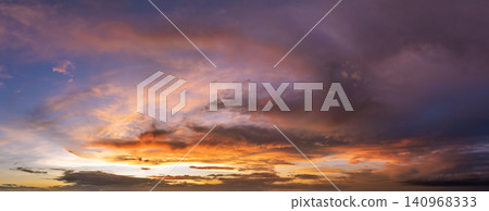 Colorful sunset sky with setting sun behind vivid orange and yellow clouds Colorful sunset sky with setting sun behind vivid orange and yellow clouds 140968333