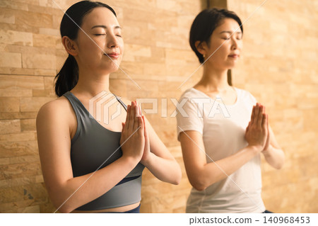Two young women doing hot yoga. Beauty image. Two young women doing hot yoga. Beauty image. 140968453