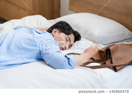 一個年輕人在床上睡著了,早上醒來 一個年輕人在床上睡著了,早上醒來 140968478