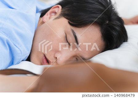 A young man who falls asleep in bed and wakes up in the morning A young man who falls asleep in bed and wakes up in the morning 140968479