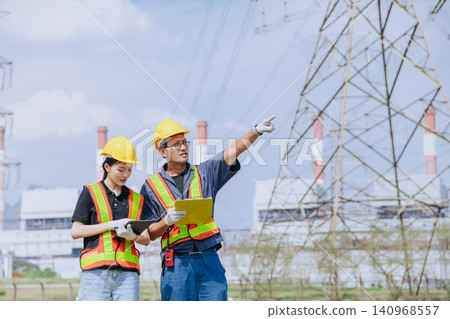 Electricity engineer working team against power plant background and power line survey inspector Electricity engineer working team against power plant background and power line survey inspector 140968557