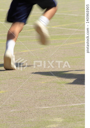 At the feet of students running on the school grounds during a foot race at an elementary school sports day. At the feet of students running on the school grounds during a foot race at an elementary school sports day. 140968905