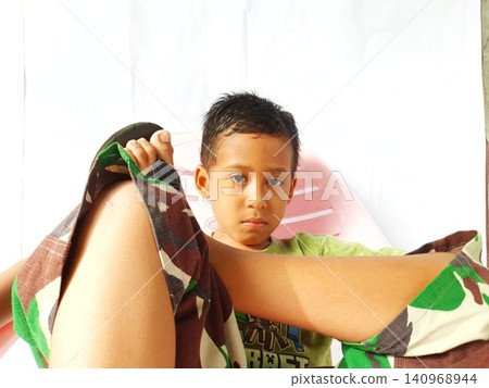 Determined Young Boy Raising His Fist with Serious Gaze Determined Young Boy Raising His Fist with Serious Gaze 140968944