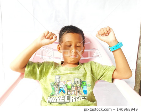 Determined Young Boy Raising His Fist with Serious Gaze Determined Young Boy Raising His Fist with Serious Gaze 140968949