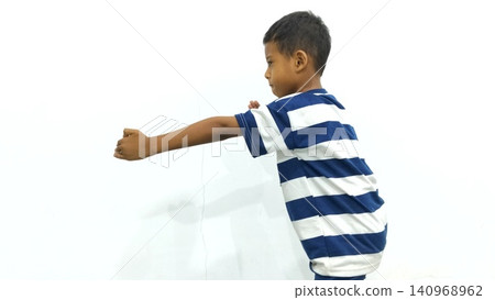 Determined Young Boy Raising His Fist with Serious Gaze Determined Young Boy Raising His Fist with Serious Gaze 140968962