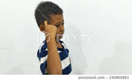 Determined Young Boy Raising His Fist with Serious Gaze Determined Young Boy Raising His Fist with Serious Gaze 140968963
