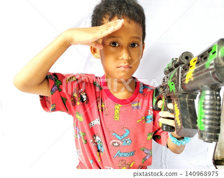Determined Young Boy Raising His Fist with Serious Gaze Determined Young Boy Raising His Fist with Serious Gaze 140968975