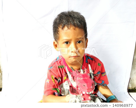 Determined Young Boy Raising His Fist with Serious Gaze 140968977