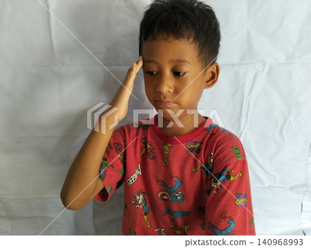 Determined Young Boy Raising His Fist with Serious Gaze 140968993