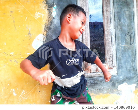 Determined Young Boy Raising His Fist with Serious Gaze Determined Young Boy Raising His Fist with Serious Gaze 140969010