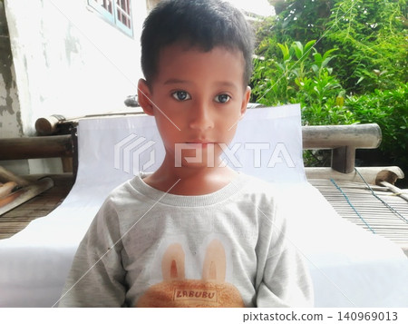 Determined Young Boy Raising His Fist with Serious Gaze Determined Young Boy Raising His Fist with Serious Gaze 140969013