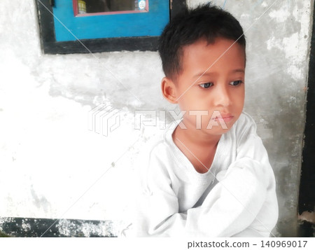Determined Young Boy Raising His Fist with Serious Gaze Determined Young Boy Raising His Fist with Serious Gaze 140969017