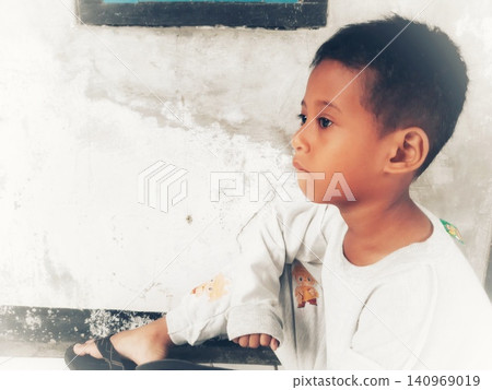 Determined Young Boy Raising His Fist with Serious Gaze Determined Young Boy Raising His Fist with Serious Gaze 140969019
