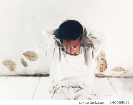 Determined Young Boy Raising His Fist with Serious Gaze 140969021