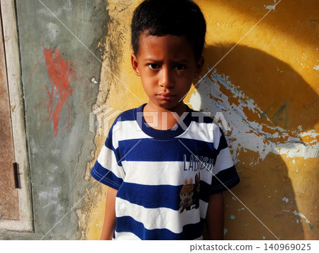 Determined Young Boy Raising His Fist with Serious Gaze Determined Young Boy Raising His Fist with Serious Gaze 140969025