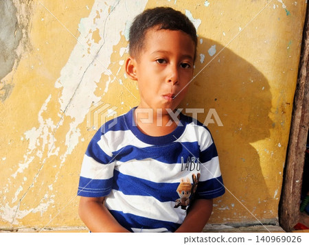 Determined Young Boy Raising His Fist with Serious Gaze Determined Young Boy Raising His Fist with Serious Gaze 140969026