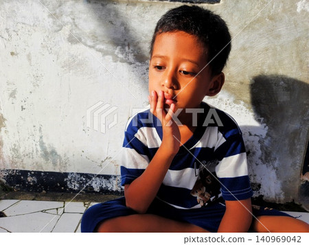 Determined Young Boy Raising His Fist with Serious Gaze Determined Young Boy Raising His Fist with Serious Gaze 140969042