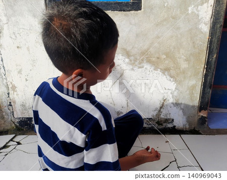 Determined Young Boy Raising His Fist with Serious Gaze Determined Young Boy Raising His Fist with Serious Gaze 140969043