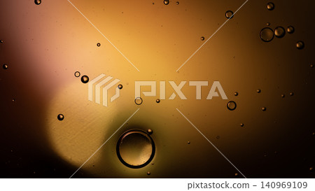 Close-up of amber orange liquid with scattered bubbles and soft glow. Warm gradient lighting creates a dreamy, glossy surface with translucent spheres Close-up of amber orange liquid with scattered bubbles and soft glow. Warm gradient lighting creates a dreamy, glossy surface with translucent spheres 140969109