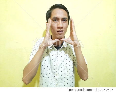 Young Asian Man Feeling Stressed with Headache Against Yellow Wall Young Asian Man Feeling Stressed with Headache Against Yellow Wall 140969607