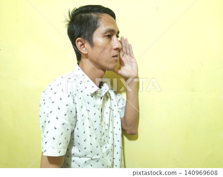 Young Asian Man Feeling Stressed with Headache Against Yellow Wall Young Asian Man Feeling Stressed with Headache Against Yellow Wall 140969608