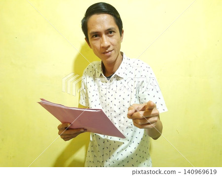 Young Asian Man Feeling Stressed with Headache Against Yellow Wall Young Asian Man Feeling Stressed with Headache Against Yellow Wall 140969619