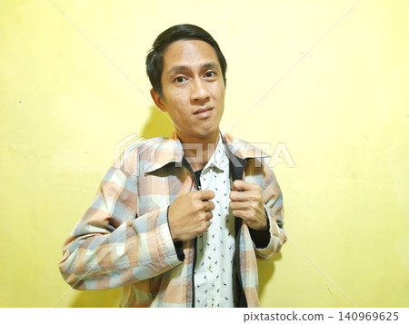 Young Asian Man Feeling Stressed with Headache Against Yellow Wall Young Asian Man Feeling Stressed with Headache Against Yellow Wall 140969625