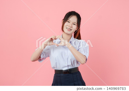 Portrait Thai student in uniform, Asian teen girl cute pretty cheerful happy smiling, Love sign hand Portrait Thai student in uniform, Asian teen girl cute pretty cheerful happy smiling, Love sign hand 140969783