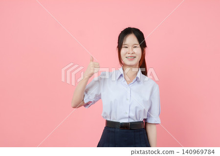 Portrait Thai student in uniform, Asian teen girl cute pretty cheerful happy smiling, Thumbs up. Portrait Thai student in uniform, Asian teen girl cute pretty cheerful happy smiling, Thumbs up. 140969784