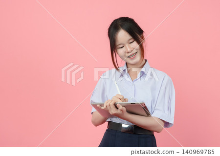 Portrait Thai student in uniform, Asian teen girl cute pretty cheerful happy smiling with tablet Portrait Thai student in uniform, Asian teen girl cute pretty cheerful happy smiling with tablet 140969785