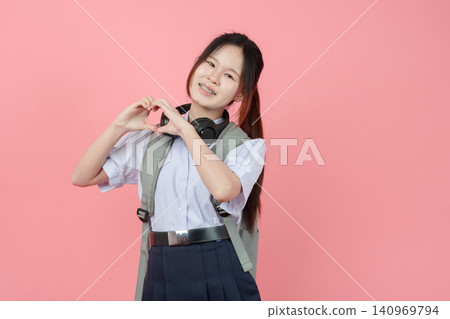 Portrait Thai student in uniform, Asian teen girl cute pretty cheerful happy smiling, Love sign hand Portrait Thai student in uniform, Asian teen girl cute pretty cheerful happy smiling, Love sign hand 140969794