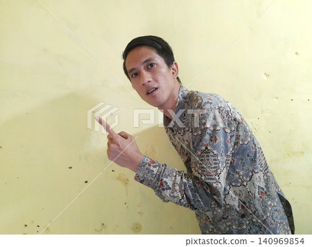 Energetic Asian Man in Batik Showing Hands with Surprised Expression 140969854
