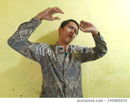 Energetic Asian Man in Batik Showing Hands with Surprised Expression Energetic Asian Man in Batik Showing Hands with Surprised Expression 140969859