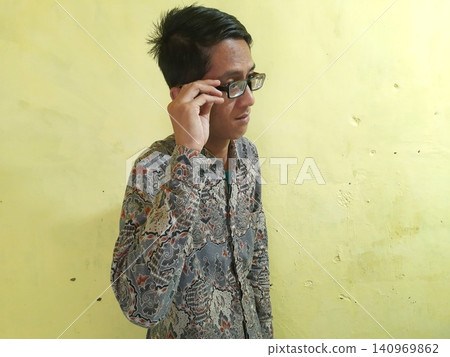 Energetic Asian Man in Batik Showing Hands with Surprised Expression Energetic Asian Man in Batik Showing Hands with Surprised Expression 140969862