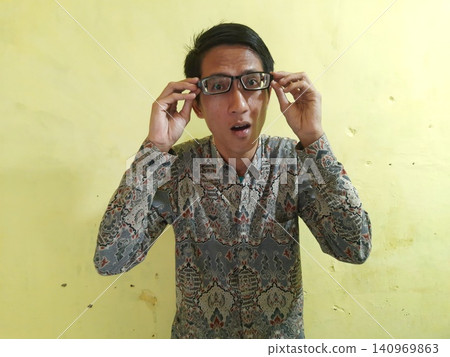 Energetic Asian Man in Batik Showing Hands with Surprised Expression Energetic Asian Man in Batik Showing Hands with Surprised Expression 140969863