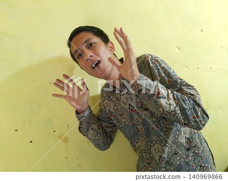 Energetic Asian Man in Batik Showing Hands with Surprised Expression Energetic Asian Man in Batik Showing Hands with Surprised Expression 140969866