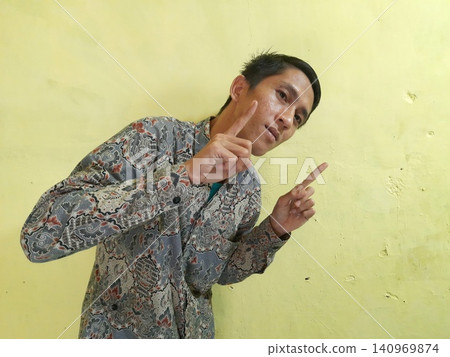 Energetic Asian Man in Batik Showing Hands with Surprised Expression 140969874