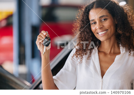 Woman showing car key. Enjoy fix car service. Satisfied car maintenance in garage, Sell Rent car Woman showing car key. Enjoy fix car service. Satisfied car maintenance in garage, Sell Rent car 140970106