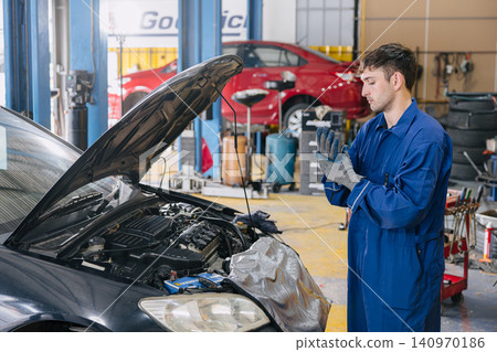 Garage Mechanic worker in auto service center working car engine service maintenance under hood. Garage Mechanic worker in auto service center working car engine service maintenance under hood. 140970186