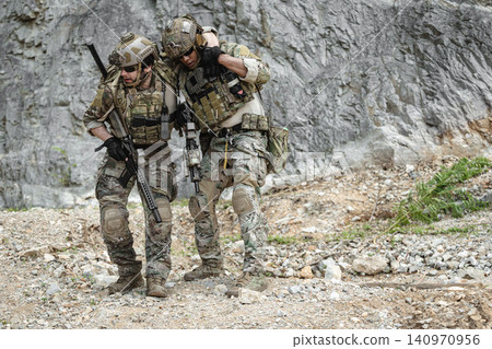 Marine Special Forces commando providing soldier injured evacuation assistance during military operation Marine Special Forces commando providing soldier injured evacuation assistance during military operation 140970956
