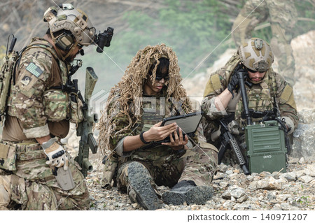 Military communications soldier operating tactical radio equipment during field mission Military communications soldier operating tactical radio equipment during field mission 140971207