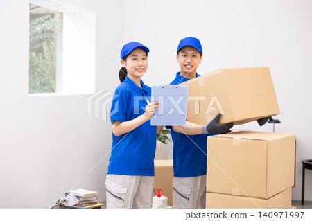 Moving - Moving staff carrying cardboard boxes Moving - Moving staff carrying cardboard boxes 140971997