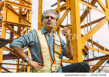 Professional Italian construction engineer building site manager. Foreman operate crane tower work. Professional Italian construction engineer building site manager. Foreman operate crane tower work. 140972096