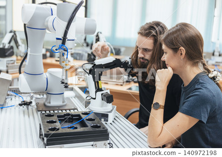 Young engineer team working in Robotic lab test program robot prototype. Robotic factory research. Young engineer team working in Robotic lab test program robot prototype. Robotic factory research. 140972198