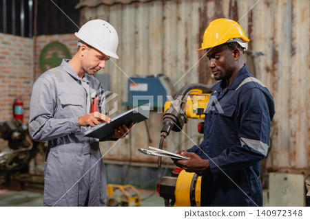 Professional engineer workers team working in metal workshop talking and working together Professional engineer workers team working in metal workshop talking and working together 140972348