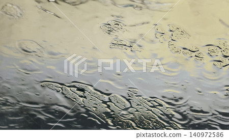 Dreamy abstract wet glass surface with warm yellow and cool blue reflections Dreamy abstract wet glass surface with warm yellow and cool blue reflections 140972586