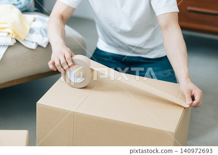 Moving - A man's hands as he packs Moving - A man's hands as he packs 140972693