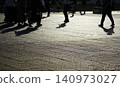 People walking down the city streets and their silhouettes 140973027